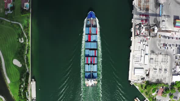 Cargo Ship Filled with Freight Moves Between the Residential Area and the Docks in Port Miami alt