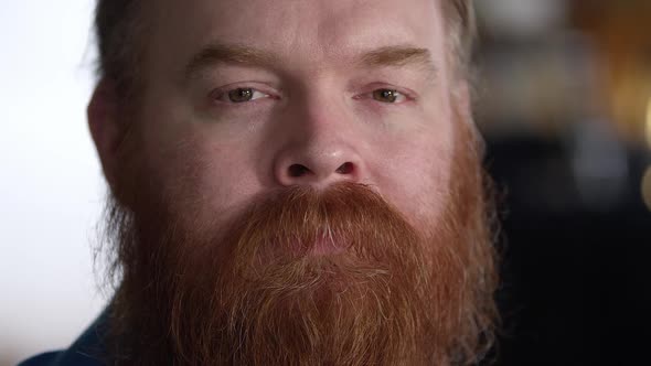 Close up to man with thick red beard with sad face