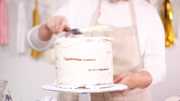 Step by step. Pastry chef stacking cake layers with buttercream frosting between to create unicorn c