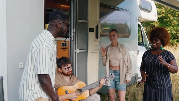 A Multicultural Group of Good Old Friends Singing and Dancing Near Their Camper Van