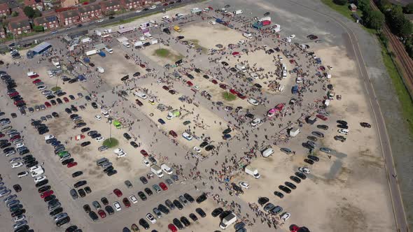 Floating high aerial birdseye drone shot towards a busy market and car boot sale in Hull England UK