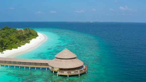 Aerial View of the Stilt Hut with Palm Thatch Roof with Turquoise Indian Ocean on the White Sand