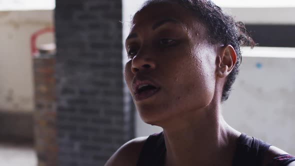 Portrait of african american woman standing and resting after exercise in an empty urban building