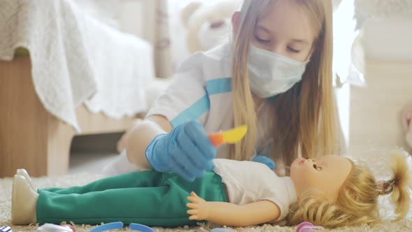 Beautiful Little Girl Playing Doctors with Doll at Home