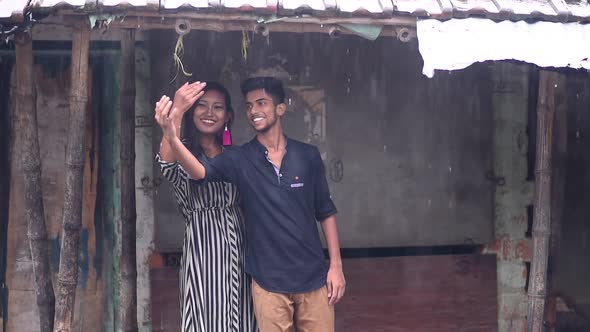 Romantic cute couple in love smiling and stuck in rain and having fun, slow motion