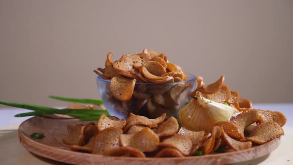 Tasty bread crumbs with onion and sour cream on a wooden plate