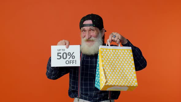 Senior Bearded Man Showing Shopping Bags and Up To 50 Percent Off Inscriptions Banner Black Friday