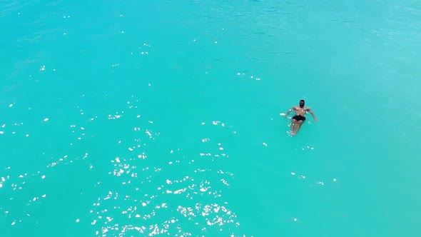 A Young Male Model Swimming Alone In the Turquoise Caribbean Sea In Slow-Motion