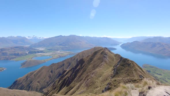 Wide scenic view from the top of Roys Peak onto Lake Wanaka and the mountains of Mount Aspiring Nati