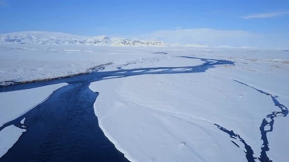 Aerial View of a Blue River in a Snowy Landscape