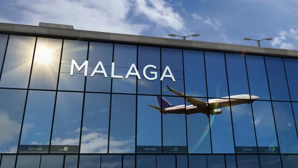 Airplane landing at Malaga Spain airport mirrored in terminal