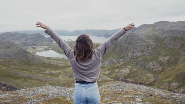 Woman meditating in peace on rock in nature