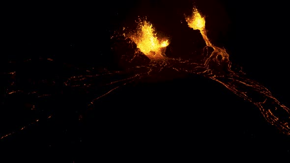 Aerial flying back from an active erupting volcano at night.