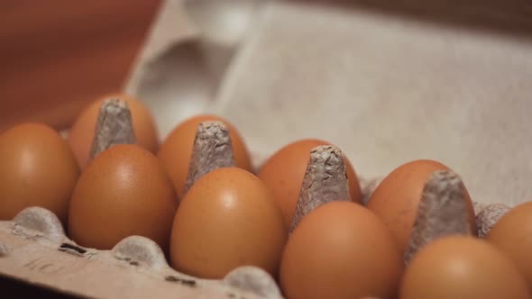 Eggs in a cardboard box on wooden table background