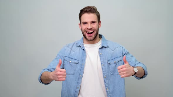 smiling young caucasian man showing thumbs up