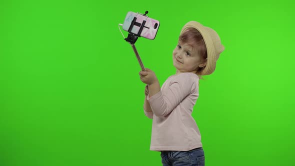 Girl Child Makes Selfie, Blogging on Mobile Phone Using Selfie Stick. Chroma Key