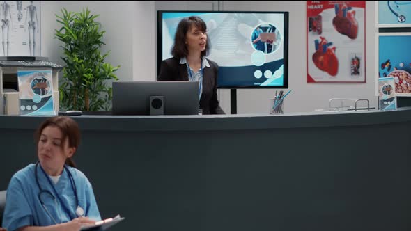 Busy Hospital Reception Desk with Diverse People Filling in Report