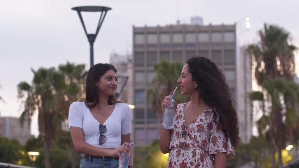 Multiethnic Teenage Girls Drinking Water From Bottle with Paper Straws