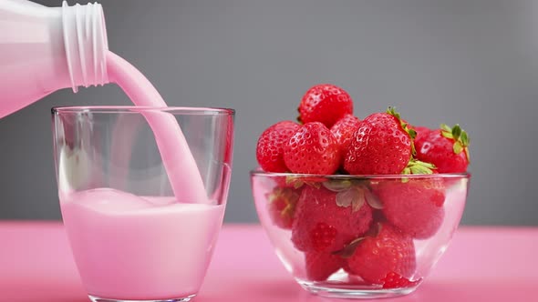 Pouring Dairy Fresh Yogurt Into Glass From Bottle for Summer Strawberry Dessert Snack or Breakfast