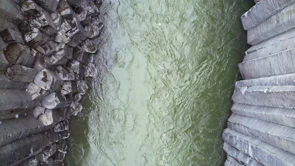 Looking down on the Studlagil River flowing between large basalt natural pillars