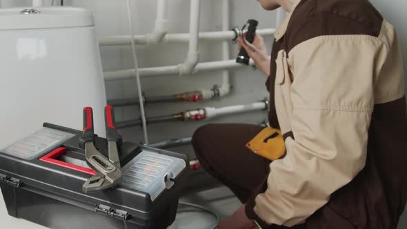 Male Plumber Inspecting Pipes