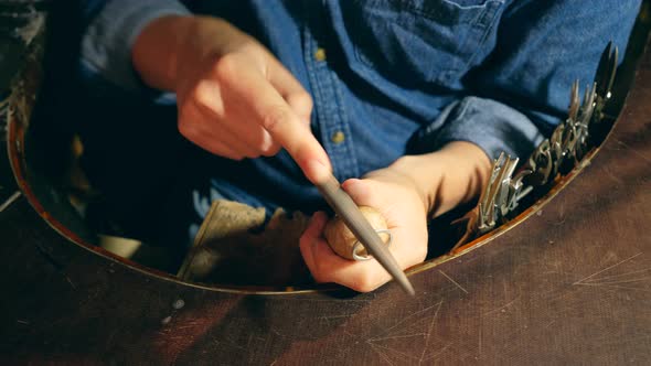 Male Silversmith Is Burning the Frame of the Silver Ring. A Ring Is Getting Polished By the