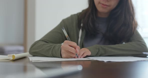 Woman write on the note do revision at home