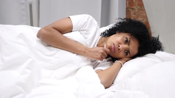 Thinking Pensive AfroAmerican Woman Lying on Side and Dreaming While in Bed