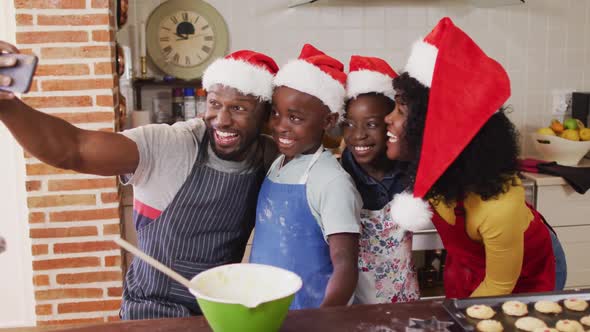 African american family taking a selfie with smartphone while baking