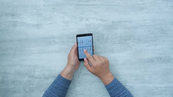 Hands Using Smart Phone With Charts And Data