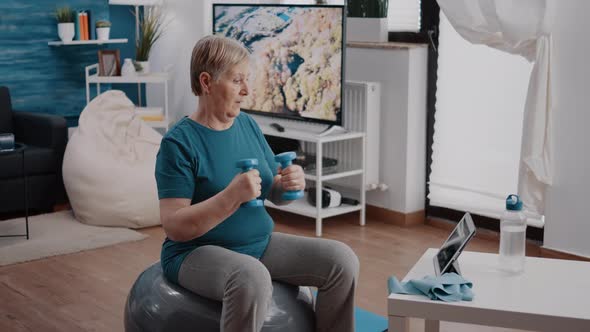 Aged Woman Watching Video of Workout Lesson on Tablet