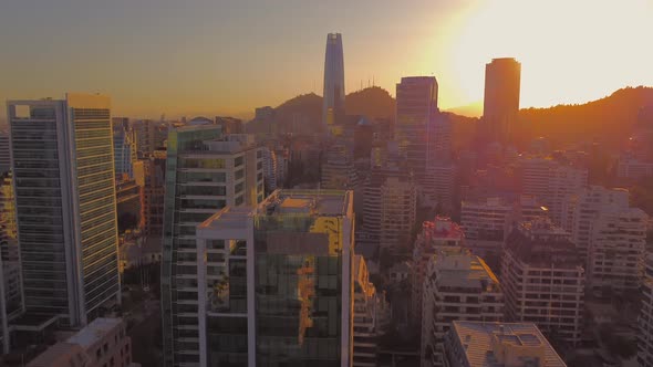 warm sunset in El Golf neighborhood, Santiago de Chile. fly by buildings in modern city.