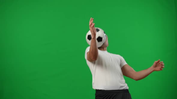 Professional Caucasian Football Player Catching Ball with Chest Posing at Chromakey Background