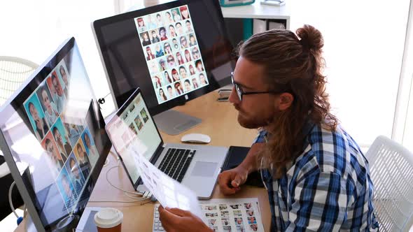 Male executive working over laptop and graphic tablet at his desk 4k