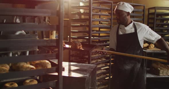 Animation of happy african american male baker holding wooden spatula with challah