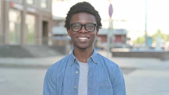 Young African Man Smiling at Camera Outdoor