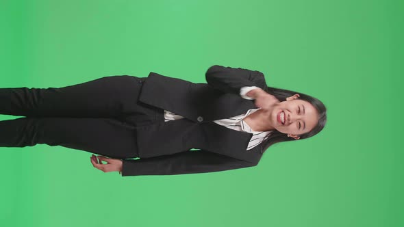 An Angry Asian Business Woman Scolding While Standing On Green Screen In The Studio