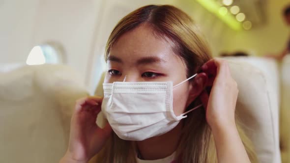 Traveler Wearing Face Mask While Traveling on Commercial Airplane