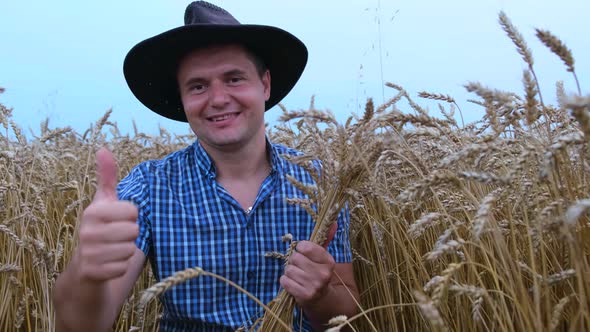 Farmer in a Hat Touching Ears of Wheat