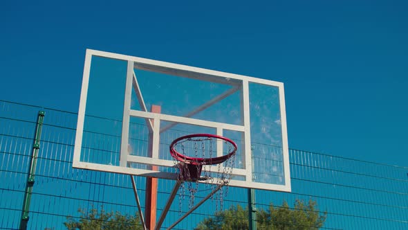 Basketball Rim with Glass Backboard Against Blue Sky