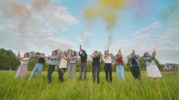 Cheerful Girls Shoot Colorful Powder From Pneumatic Clappers