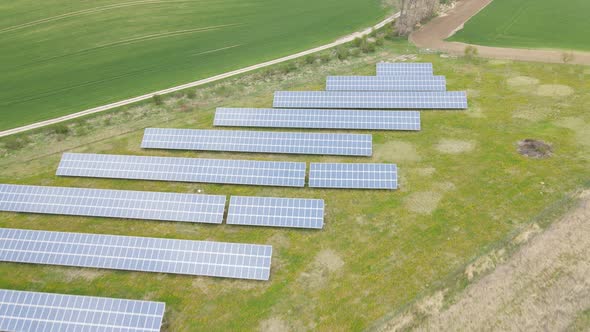 Aerial fly over shot of grid of solar panels in a solar farm in Czech republic