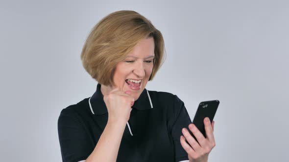 Old Woman Excited for Success While Using Smartphone