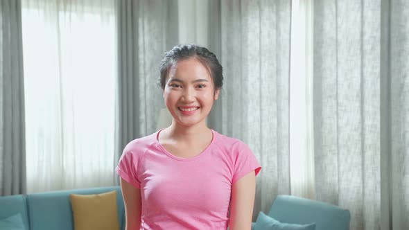 Front View Of Asian Woman Training On Walking Treadmill And Smiling At Home