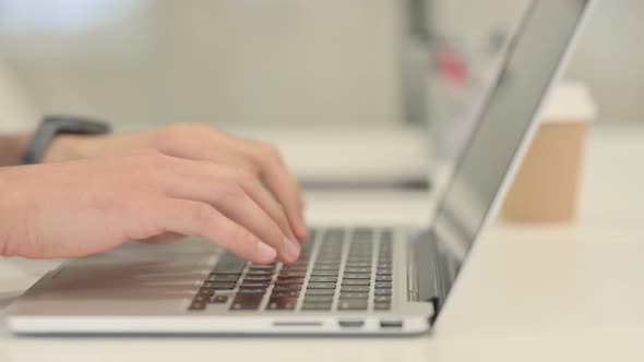 Close Up of Male Hands Typing on Laptop Side View