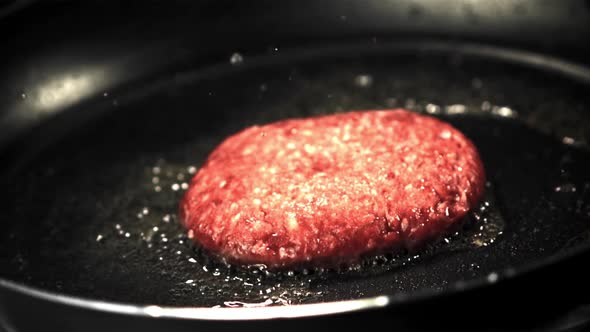 Super Slow Motion with a Splash of Oil Fried Burger in a Frying Pan