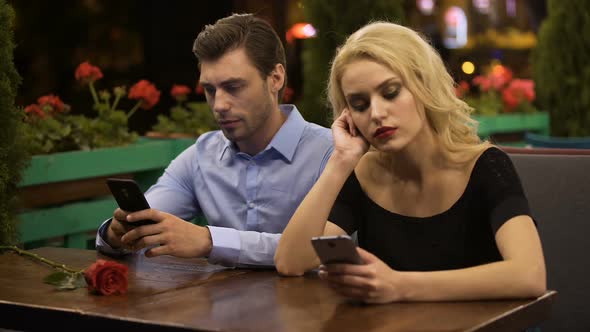 Two Young People Boring on Date, Using Smartphones, Problems in Relationship