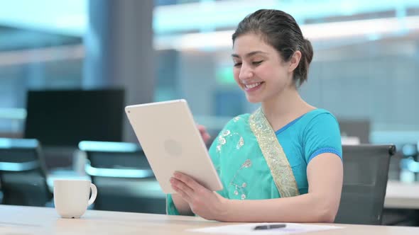 Video Call on Tablet by Young Indian Woman at Work