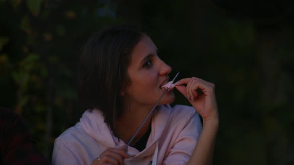 Eating a toasted marshmallow, at night