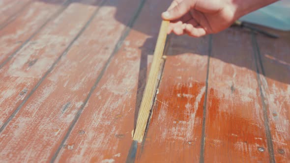 Fitting wooden spline insert into wooden boat roof planking rubbing hand across, SLOW MOTION